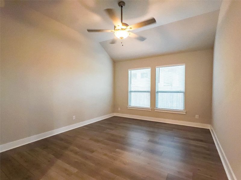 Unfurnished room featuring vaulted ceiling, dark wood-type flooring, and ceiling fan Unfurnished room featuring vaulted ceiling, dark wood-type flooring, and ceiling fan