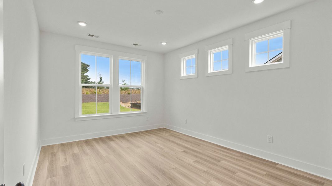 Spacious primary suite with natural light at Chestnut Farms by DRB Homes