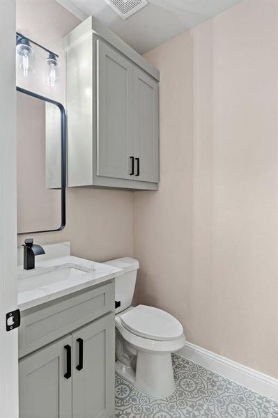 Bathroom with tile flooring, vanity, and toilet