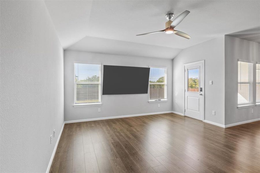 Unfurnished living room featuring lofted ceiling, ceiling fan, and dark hardwood / wood-style floors