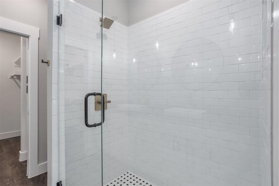 Bathroom featuring a shower stall and a closet Bathroom featuring a shower stall and a closet