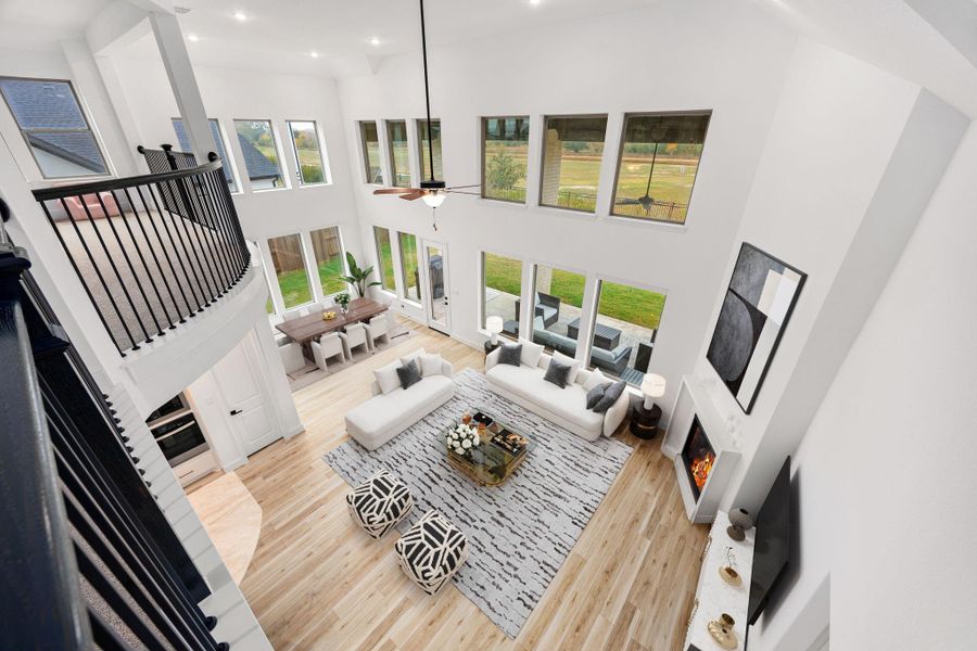 An upstairs overlook provides a view of the open living area below, highlighting the home’s soaring ceilings and open design.