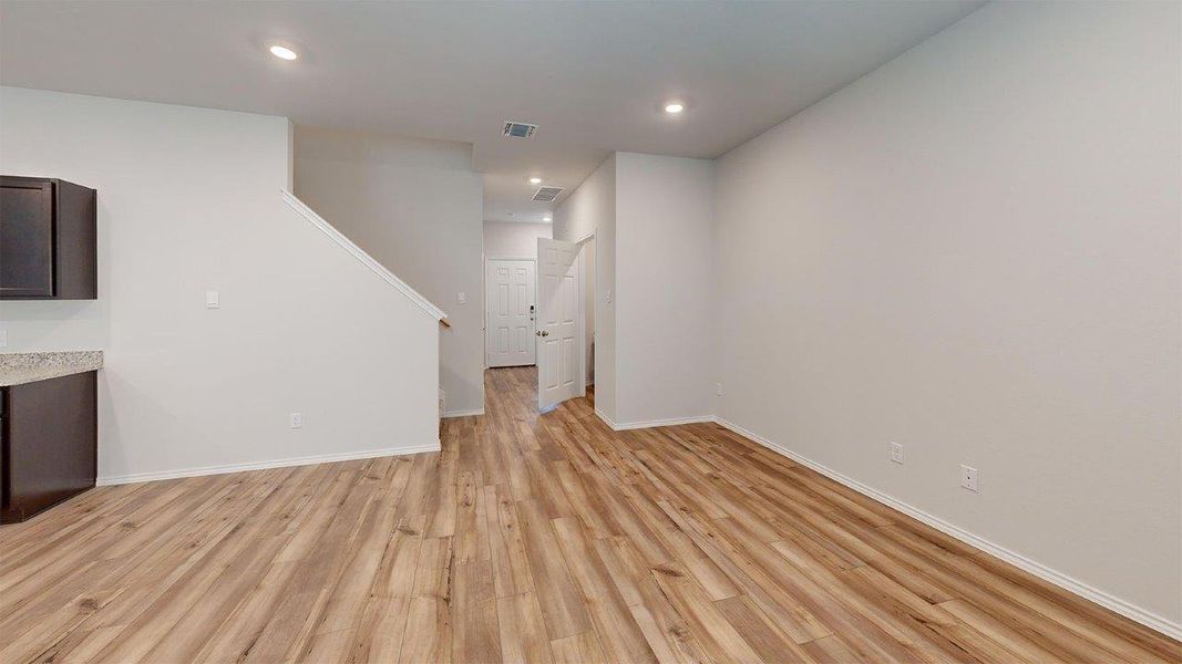 Unfurnished living room with light wood finished floors and recessed lighting Unfurnished living room with light wood finished floors and recessed lighting