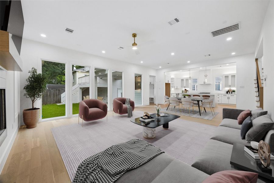 The central living and dining areas connect seamlessly to the kitchen and rear outdoor spaces, creating an ideal setup for entertaining. Large sliding glass doors and multiple window exposures bring natural light into the core of the home throughout the day. (digitally staged)