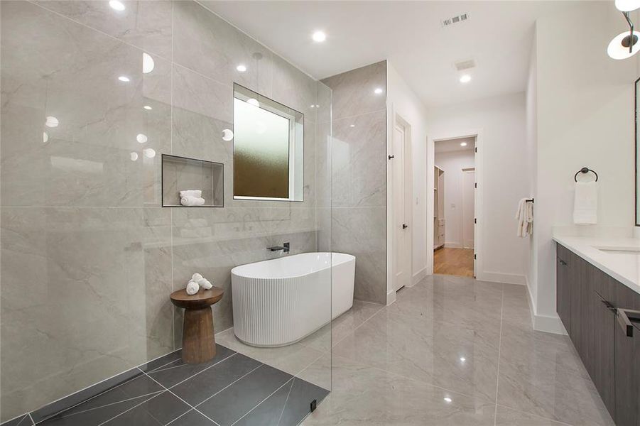 Bathroom featuring vanity, a bathtub, and tile walls