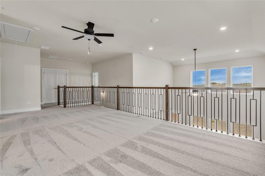 A spacious upper-level area offers versatile living space and overlooks the entry below.