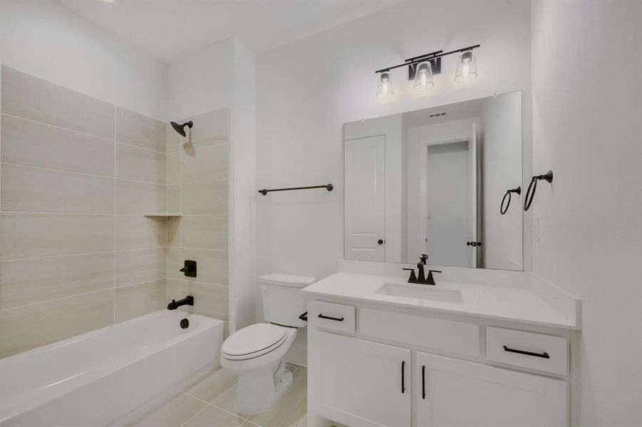 Modern bathroom featuring a white vanity with integrated sink, a large wall-mounted mirror, and a sleek three-light fixture