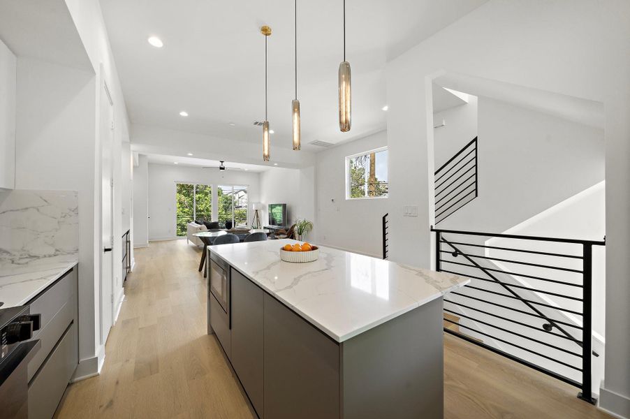 This elegant kitchen features sophisticated European-style cabinets with soft close drawers sleek, minimalist lines paired with stunning quartz countertops for a modern luxury and timeless appeal**Images shown are from a similar model. Actual features may vary.