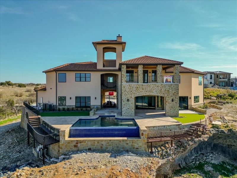 Back of house with a pool with hot tub, a balcony, and a patio area Back of house with a pool with hot tub, a balcony, and a patio area