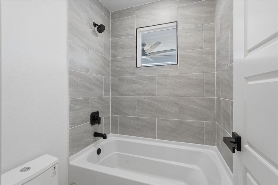 modern gray designed tub and shower combo, black hardware, Jack and Jill bathroom that connects 2 secondary bedrooms. modern gray designed tub and shower combo, black hardware, Jack and Jill bathroom that connects 2 secondary bedrooms.