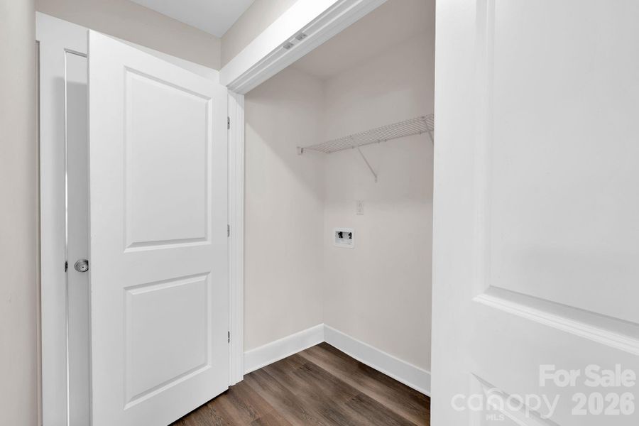 Laundry area with shelving for storage, neatly tucked away on the main level.
