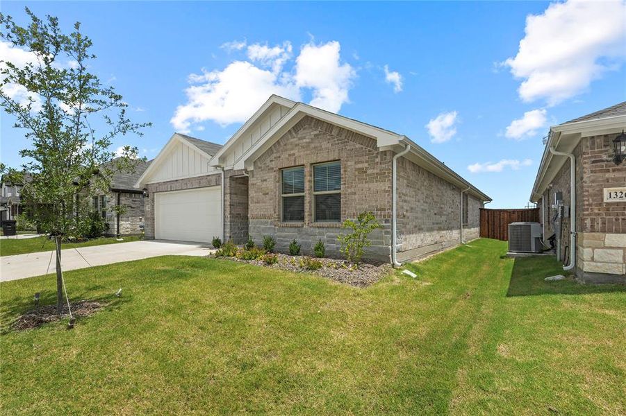 View of front of home with driveway, an attached garage, board and batten siding, and brick siding View of front of home with driveway, an attached garage, board and batten siding, and brick siding