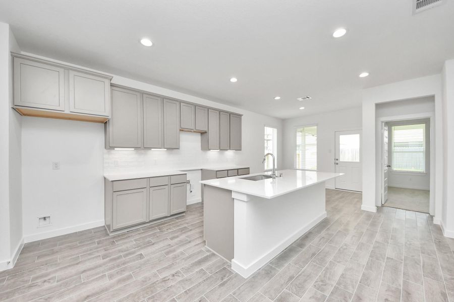 This generously spacious kitchen is a dream realized! With a massive granite island, high ceilings, soft close cabinets, granite countertops, stainless steel appliances, a sleek tile backsplash, recessed lighting, and an extended counter area, it offers both style and practicality. All this opens up to the expansive family room, creating a perfect hub for gatherings. Sample photo of completed home with similar floor plan. Actual colors and selections may vary. This generously spacious kitchen is a dream realized! With a massive granite island, high ceilings, soft close cabinets, granite countertops, stainless steel appliances, a sleek tile backsplash, recessed lighting, and an extended counter area, it offers both style and practicality. All this opens up to the expansive family room, creating a perfect hub for gatherings. Sample photo of completed home with similar floor plan. Actual colors and selections may vary.