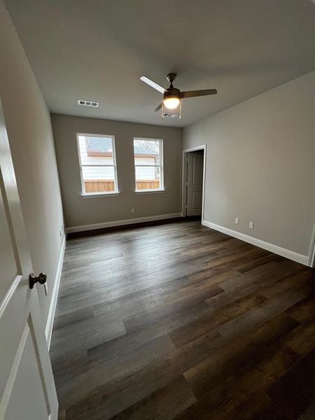 Spare room with dark wood-type flooring and ceiling fan