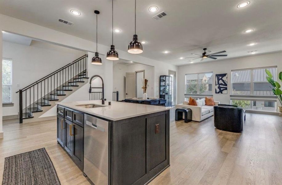 Kitchen featuring large, open island, pendant lighting, stainless appliances, light wood-type flooring, and an open floor plan Kitchen featuring large, open island, pendant lighting, stainless appliances, light wood-type flooring, and an open floor plan