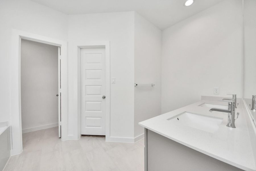 Escape to a spa-like oasis in this primary bathroom. Enjoy a walk-in shower with tile surround, a separate garden tub with custom detailing, and an elegant vanity featuring light countertops, modern hardware, and beautiful recessed lights. Experience luxury and relaxation in every detail.
