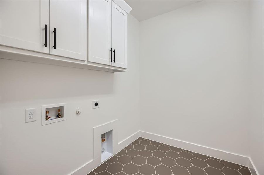 Laundry room featuring gas dryer hookup, hookup for an electric dryer, cabinet space, washer hookup, and baseboards Laundry room featuring gas dryer hookup, hookup for an electric dryer, cabinet space, washer hookup, and baseboards