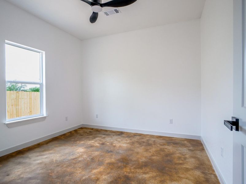 Unfurnished room with a ceiling fan, concrete floors, and baseboards