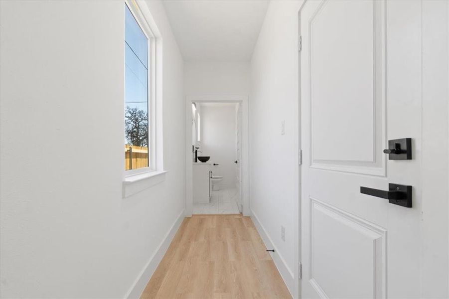 Corridor with baseboards and light wood-style floors