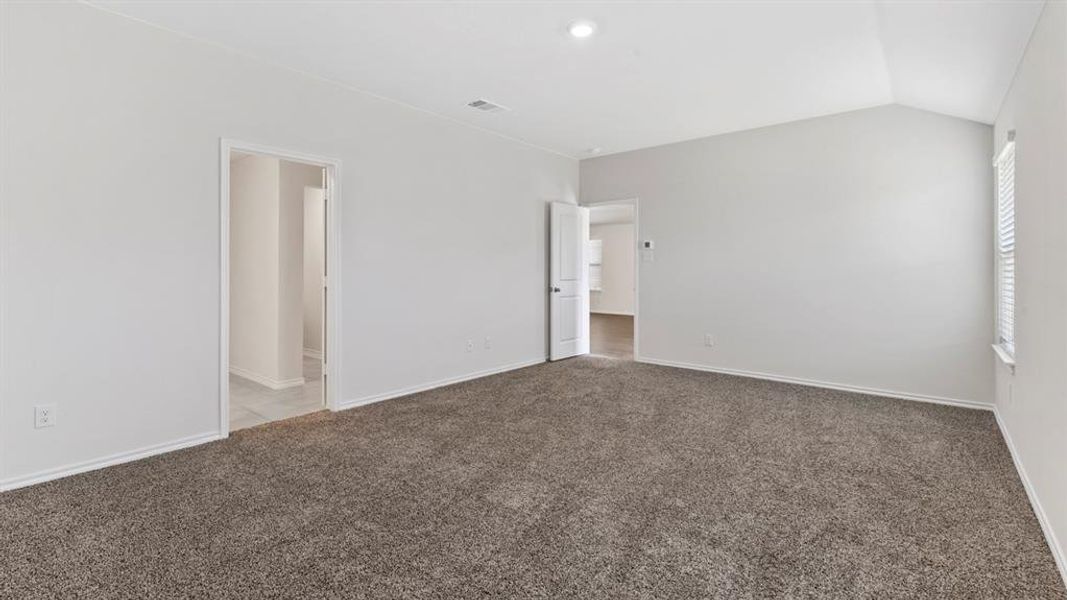 Unfurnished room featuring carpet flooring and lofted ceiling