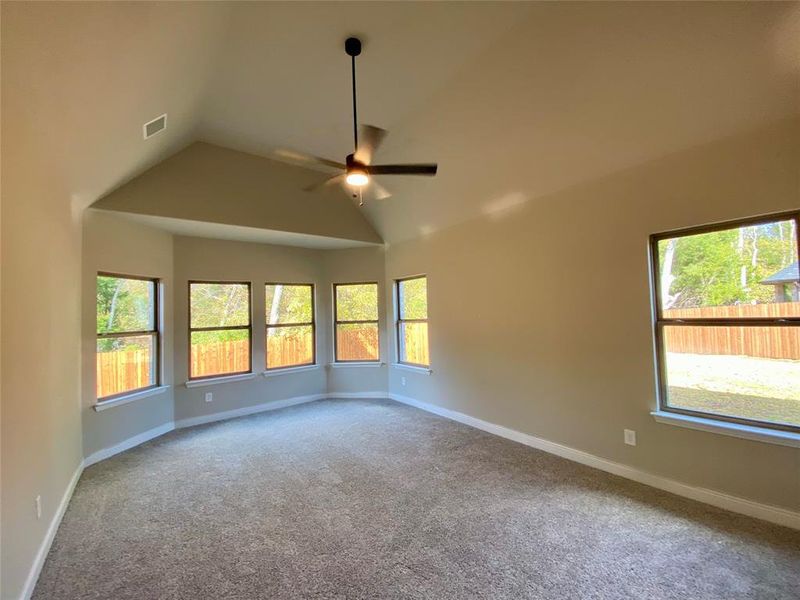 Master bedroom with bay window seating area, vaulted ceilings & fan Master bedroom with bay window seating area, vaulted ceilings & fan