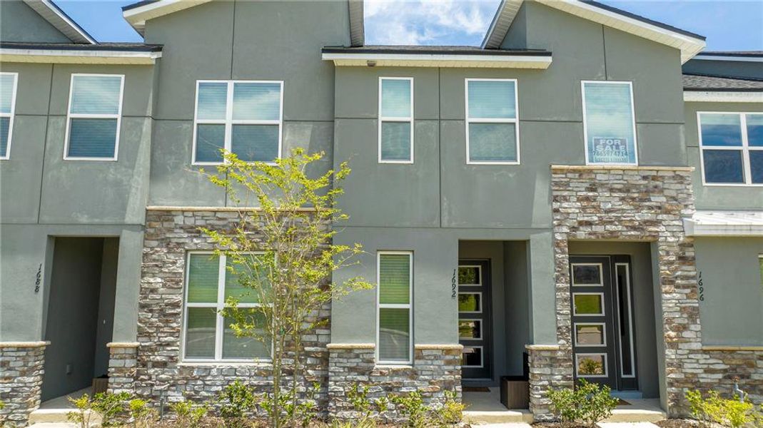 Front exterior of a new home in Solara Resort, Kissimmee, FL, highlighting curb appeal (Image 19).