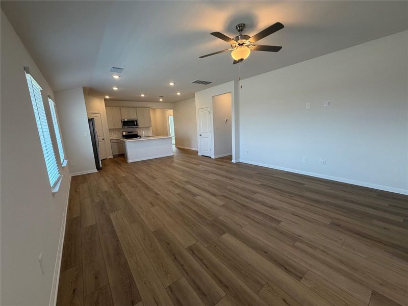 Unfurnished living room featuring dark wood-style floors, recessed lighting, and ceiling fan