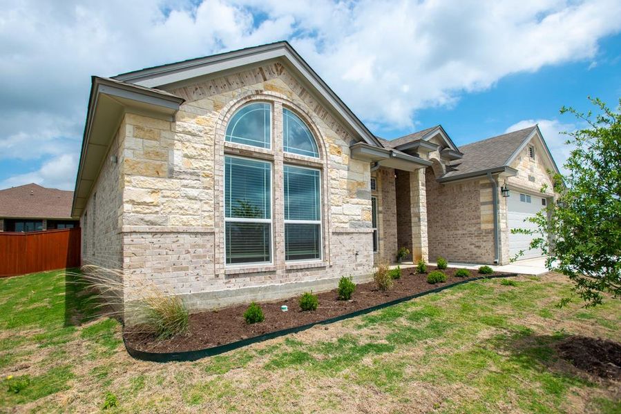 View of front of property with a garage, brick siding, and stone siding View of front of property with a garage, brick siding, and stone siding