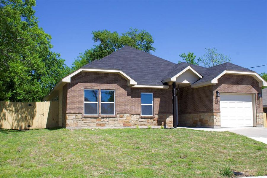 View of front of property with a garage and a front lawn