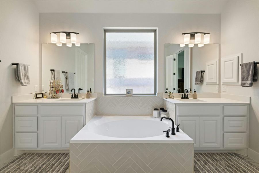 Full bath featuring two vanities and a garden tub Full bath featuring two vanities and a garden tub