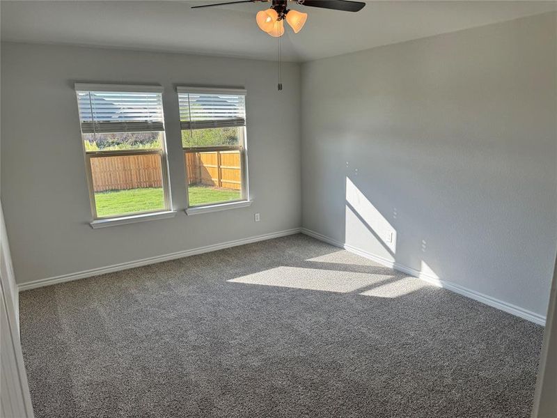 Empty room featuring carpet flooring and ceiling fan Empty room featuring carpet flooring and ceiling fan