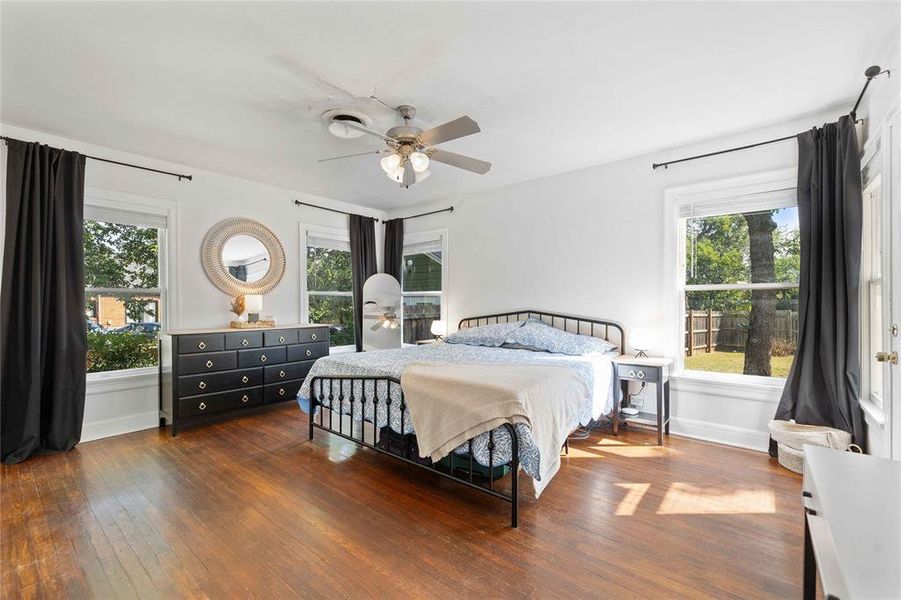 Bedroom with multiple windows, wood-type flooring, and a ceiling fan Bedroom with multiple windows, wood-type flooring, and a ceiling fan