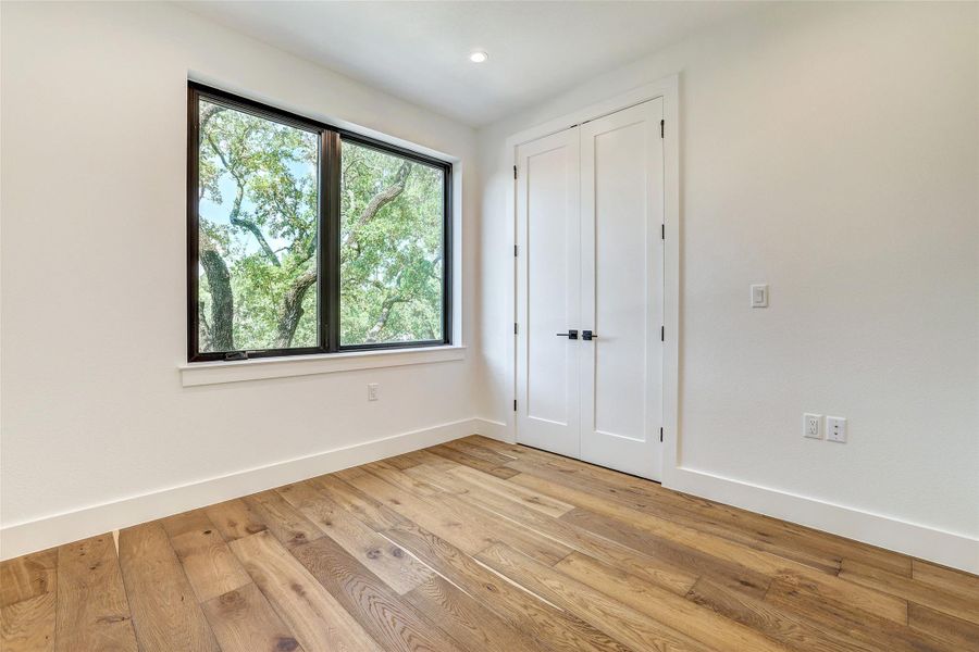 Unfurnished bedroom with light wood finished floors, baseboards, and recessed lighting