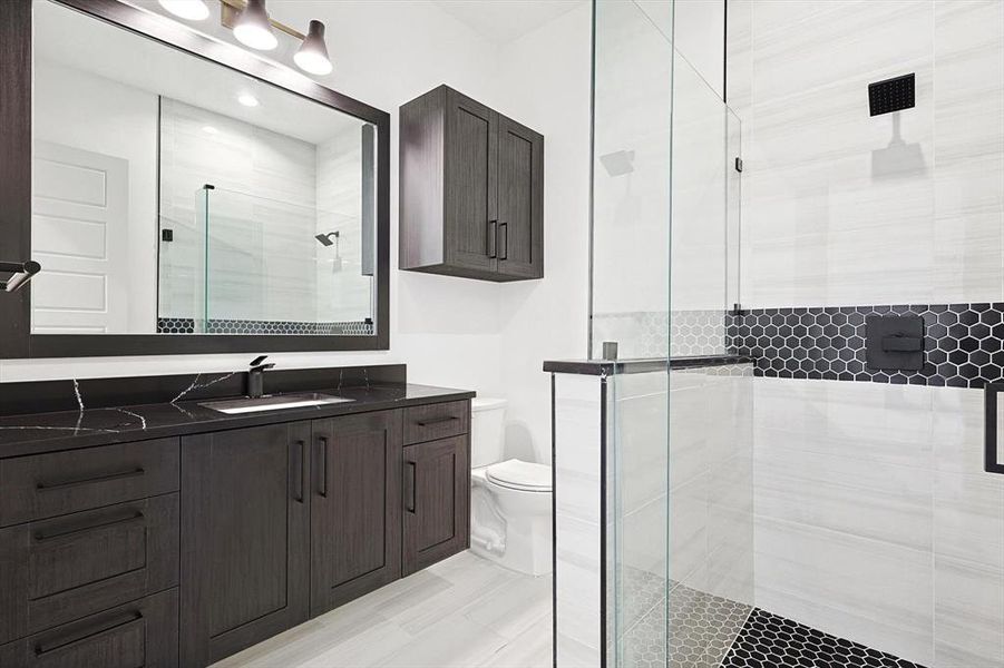 Bathroom featuring vanity, toilet, and an enclosed shower