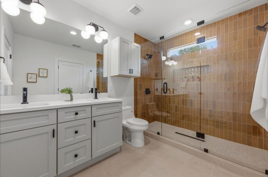 Full bathroom featuring double vanity, a stall shower, and recessed lighting