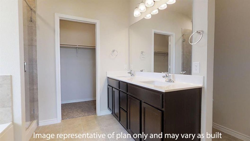 Full bath with a walk in closet, double vanity, a stall shower, and light tile patterned flooring Full bath with a walk in closet, double vanity, a stall shower, and light tile patterned flooring