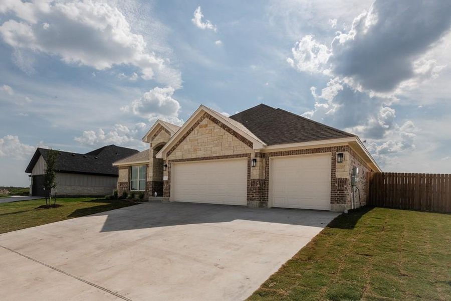 Ranch-style house featuring driveway, an attached garage, brick siding, a shingled roof, and stone siding Ranch-style house featuring driveway, an attached garage, brick siding, a shingled roof, and stone siding