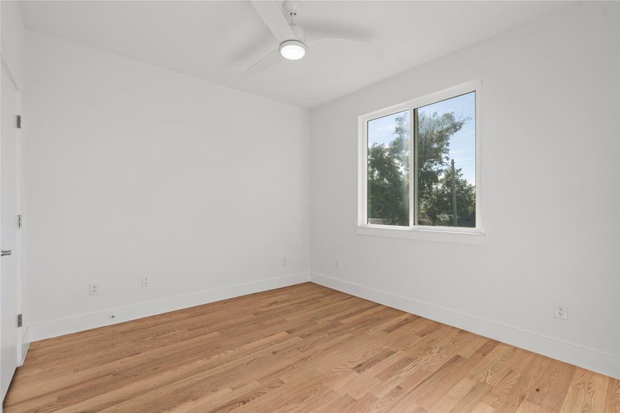 Secondary bedroom with tall windows, ceiling fan and clean architectural lines. Secondary bedroom with tall windows, ceiling fan and clean architectural lines.