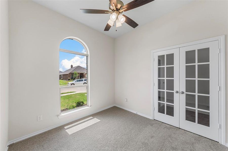 Unfurnished room with carpet floors, french doors, and baseboards Unfurnished room with carpet floors, french doors, and baseboards