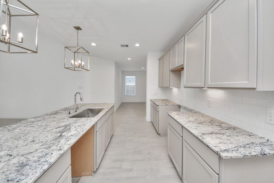 The extended counter area adds both practicality and style, making meal preparation a breeze. Every detail is thoughtfully designed to enhance the kitchen's functionality and aesthetic appeal. Sample photo of completed home with similar floor plan. Actual colors and selections may vary.