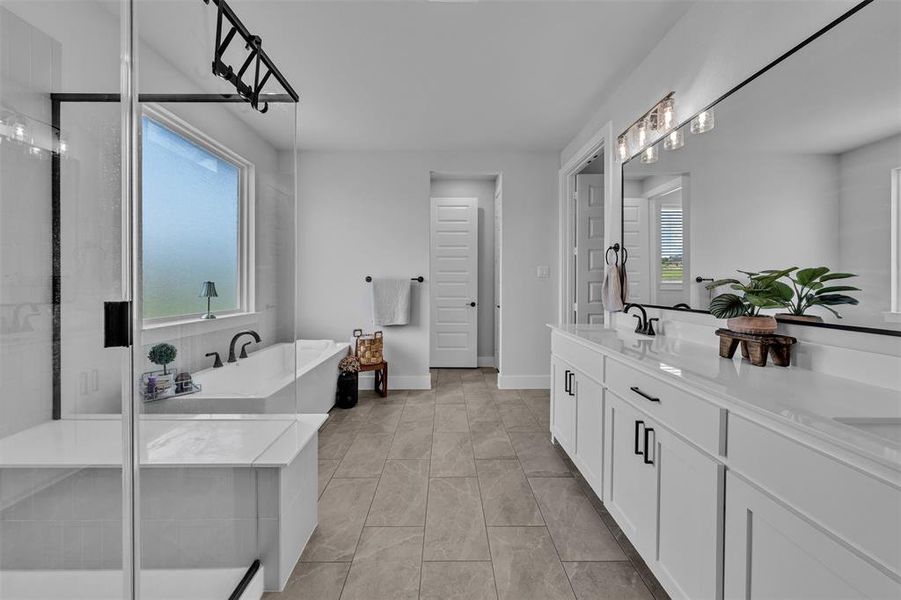 Spacious bathroom with a walk-in shower featuring a built-in bench, a separate soaking tub, a long double vanity with white cabinetry and dark hardware, a large wall-mounted mirror, and tile flooring