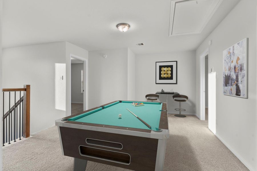 Another virtually staged view of the game room highlights its open layout and natural flow overlooking the staircase. The soft carpeting, neutral tones, and abundant light create a comfortable, welcoming space for recreation and leisure. Another virtually staged view of the game room highlights its open layout and natural flow overlooking the staircase. The soft carpeting, neutral tones, and abundant light create a comfortable, welcoming space for recreation and leisure.