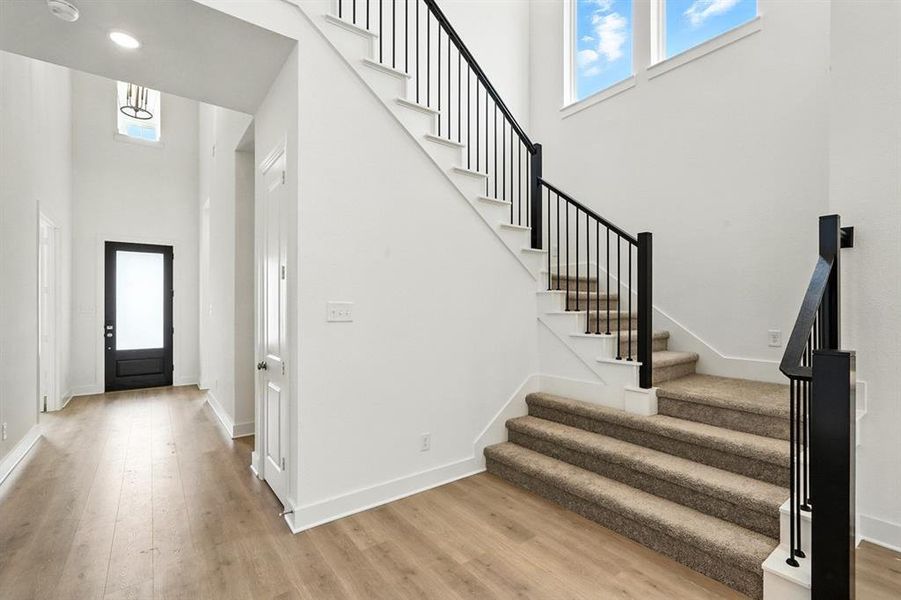 Entrance foyer featuring plenty of natural light, a high ceiling, and light wood-style flooring Entrance foyer featuring plenty of natural light, a high ceiling, and light wood-style flooring