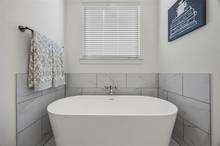 Bathroom featuring tile walls and a tub