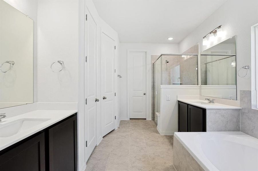 Bathroom with tile patterned floors, separate shower and tub, and vanity