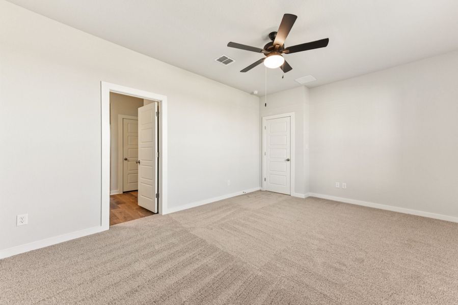 A room with a ceiling fan and a door.