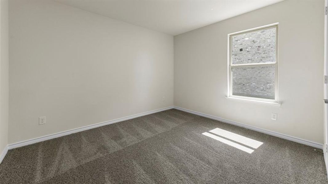 This room features neutral-toned walls, gray carpeting, and a window providing natural light
