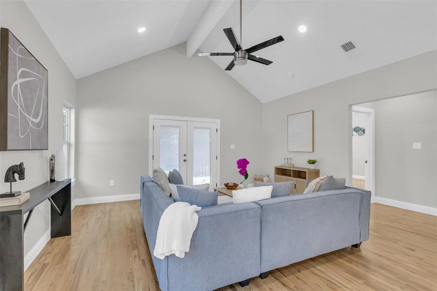 Living room with beam ceiling, french doors, light wood-style flooring, high vaulted ceiling, and ceiling fan