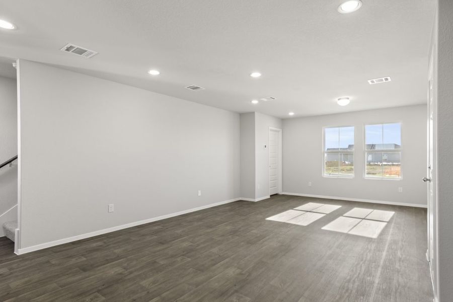 Image of a cottage home living/dining room with dark vinyl flooring, light grey walls and two large windows Image of a cottage home living/dining room with dark vinyl flooring, light grey walls and two large windows