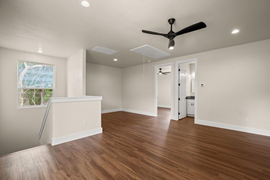 Empty room featuring attic access, ceiling fan, dark wood-type flooring, and recessed lighting